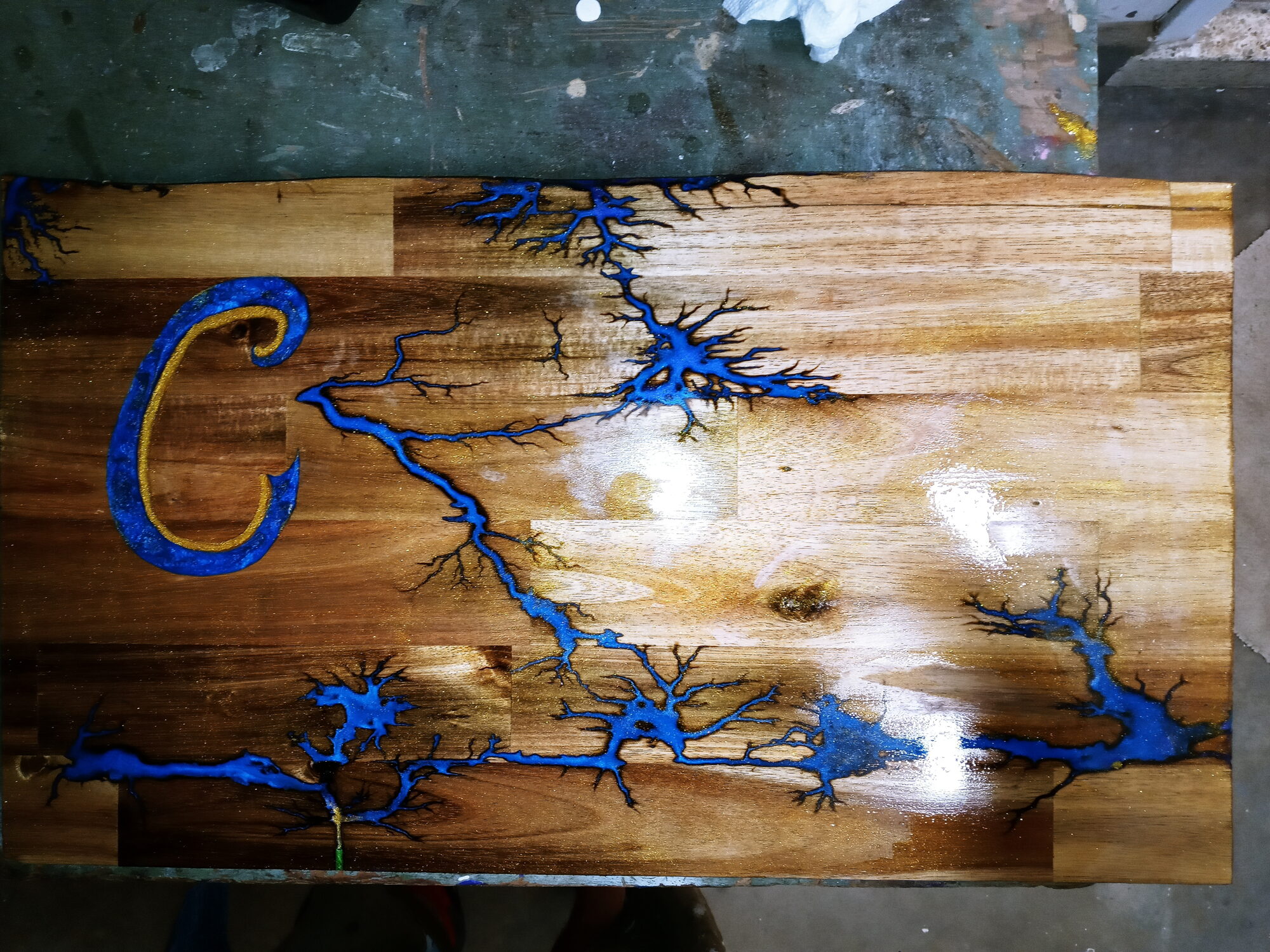 Wood board with blue resin fractals and gold monogram C