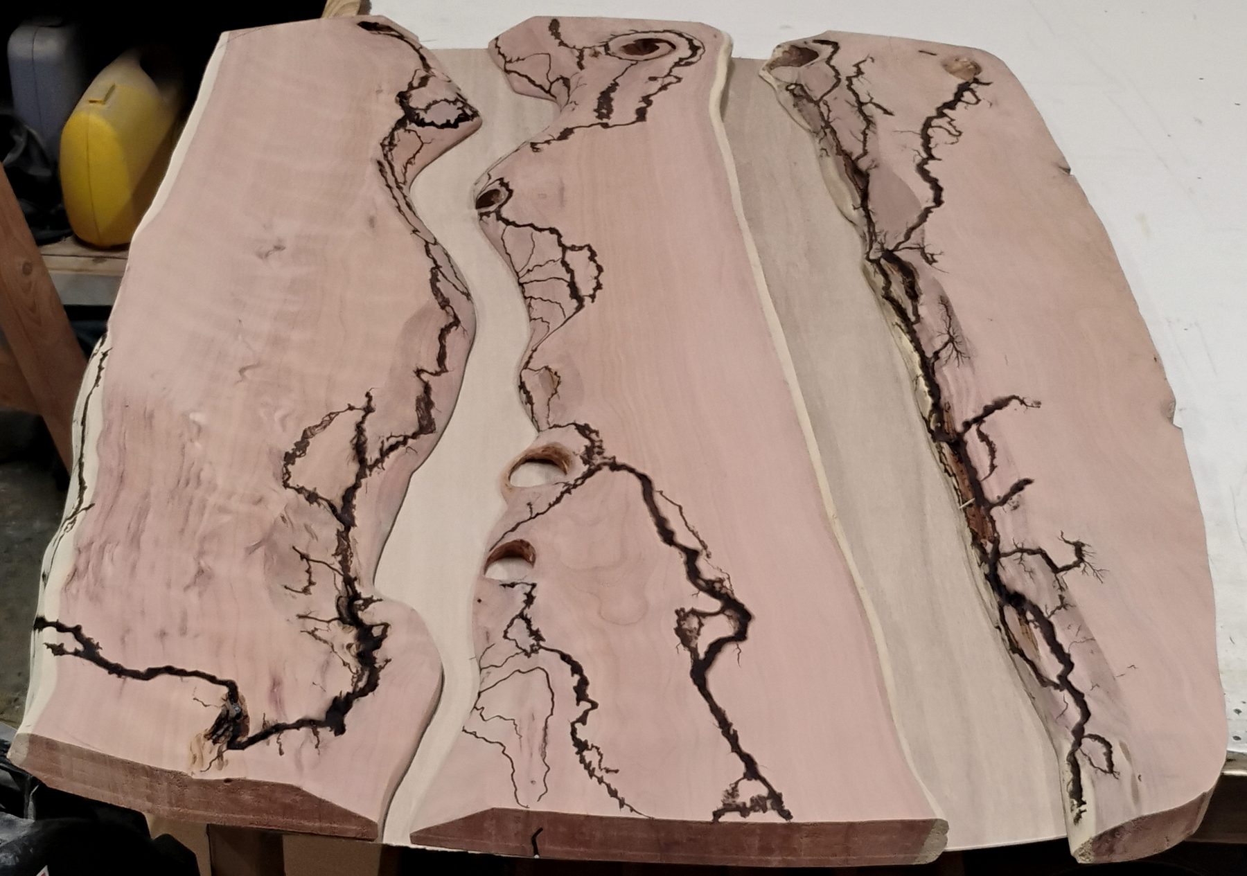 Three raw cedar slabs laid out on the bench